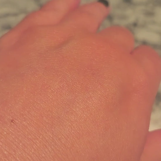 Video of Limited Edition Orange Vanilla Wild Sea Kelp Body Lotion on a hand, moving to catch the light and show its luminous shimmer.