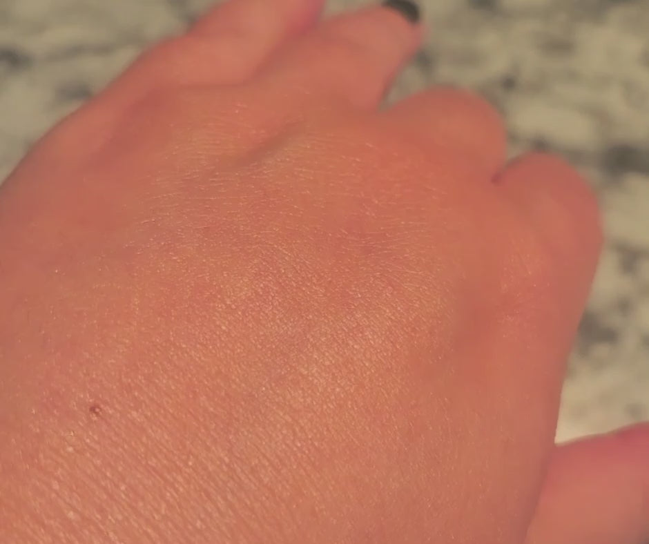 Video of Limited Edition Orange Vanilla Wild Sea Kelp Body Lotion on a hand, moving to catch the light and show its luminous shimmer.